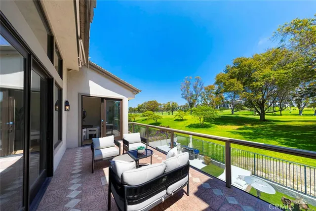 a view of a patio with couches table and chairs and wooden fence