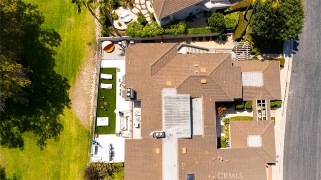 an aerial view of a house with swimming pool and large trees