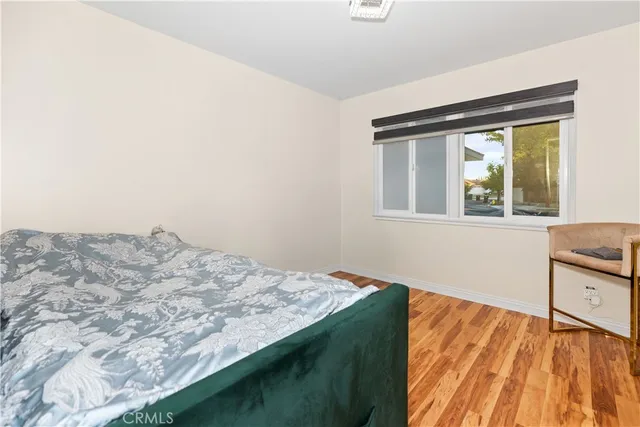 a bedroom with a bed and wooden floor