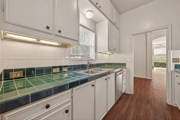 a kitchen with granite countertop white cabinets and a sink