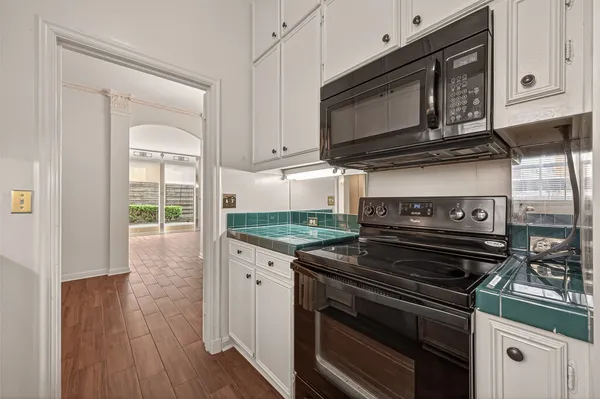 a kitchen with granite countertop white cabinets and white appliances