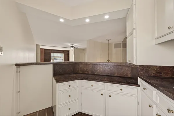 an empty room with wooden floor and a ceiling fan