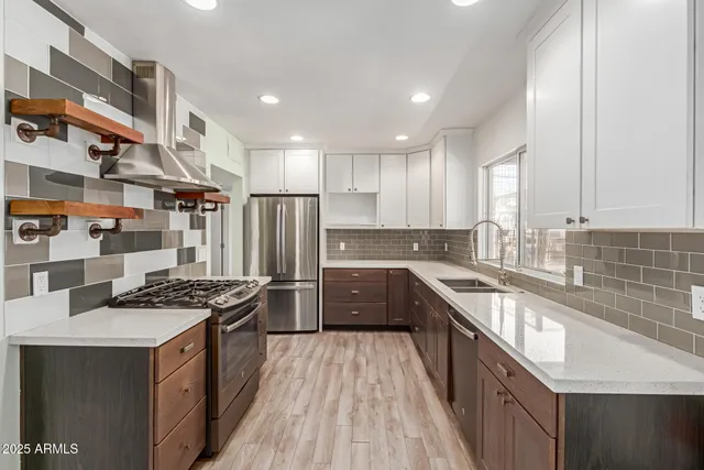 a kitchen with stainless steel appliances granite countertop a sink stove and refrigerator
