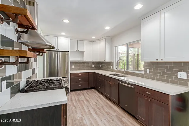 a kitchen with stainless steel appliances granite countertop a sink stove and refrigerator