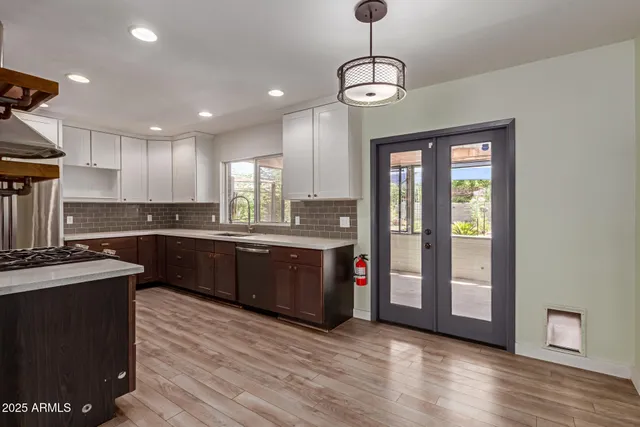 a large kitchen with stainless steel appliances granite countertop a stove and a wooden floors