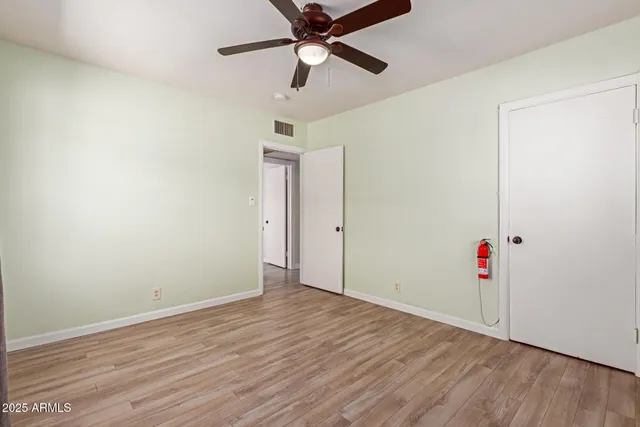 a view of a room with wooden floor and ceiling fan