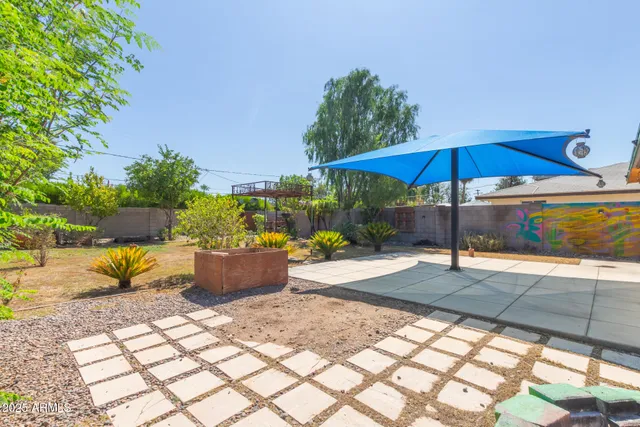 a view of a backyard and chairs under an umbrella