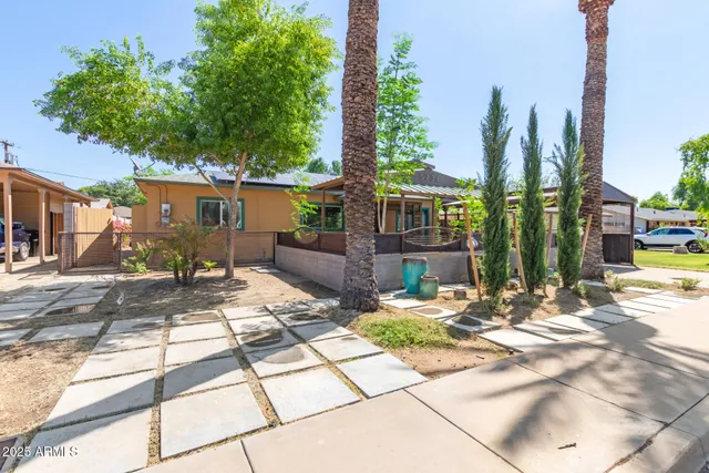 a view of a patio with table and chairs potted plants and large tree
