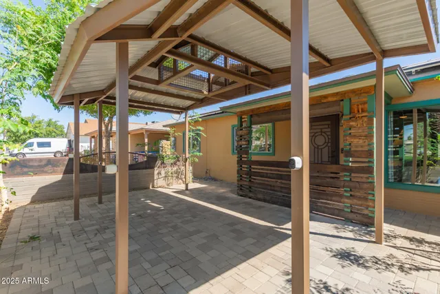 a view of a patio with table and chairs under an umbrella