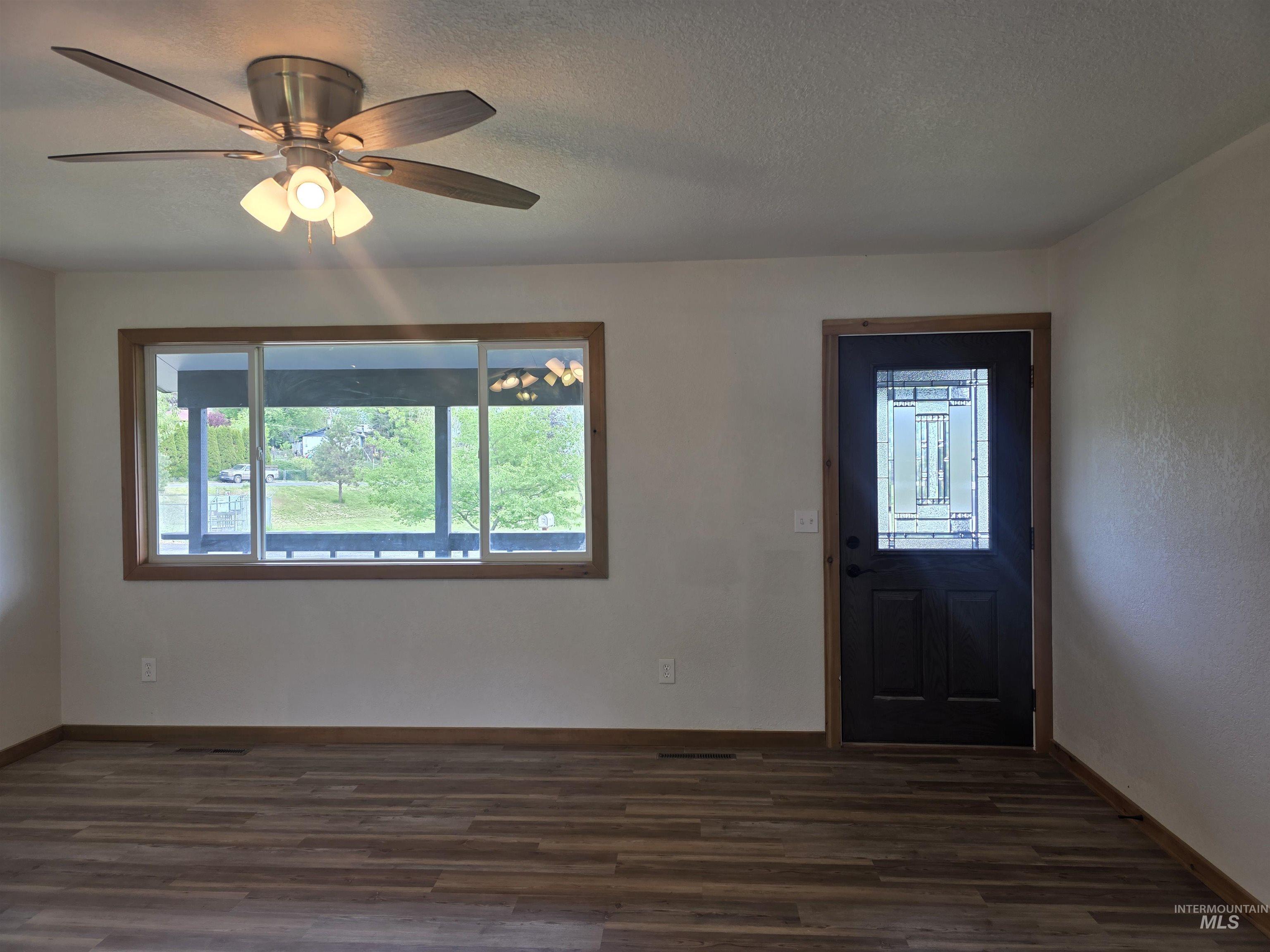 310 Fir Road Kamiah, ID 83536 - Photo 9 of 32 Spacious room featuring wood-finish flooring, white walls, and wood trim throughout