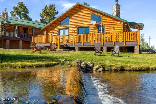 a view of a house with swimming pool lawn chairs and a yard