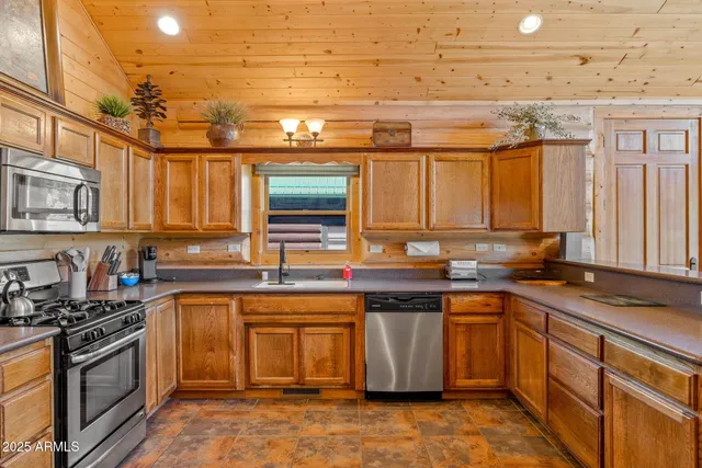 a kitchen with stainless steel appliances granite countertop a sink stove and cabinets