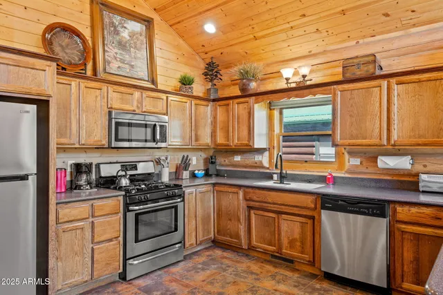 a kitchen with stainless steel appliances granite countertop a sink a stove and cabinets