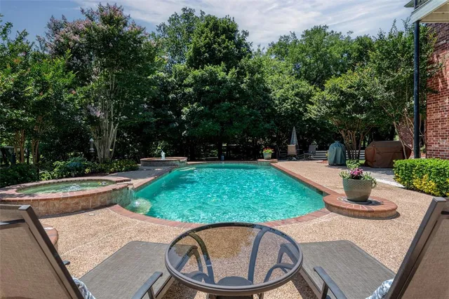 a swimming pool with outdoor seating and trees