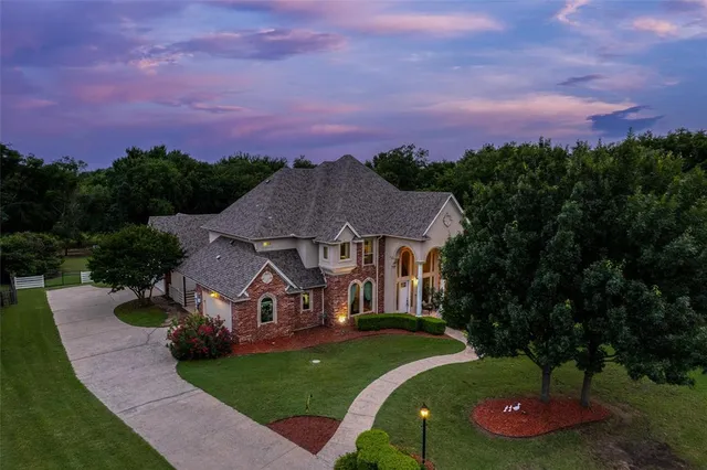 a front view of a house with a garden and trees