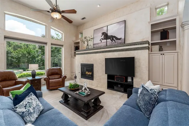 a living room with furniture a large window and a fireplace