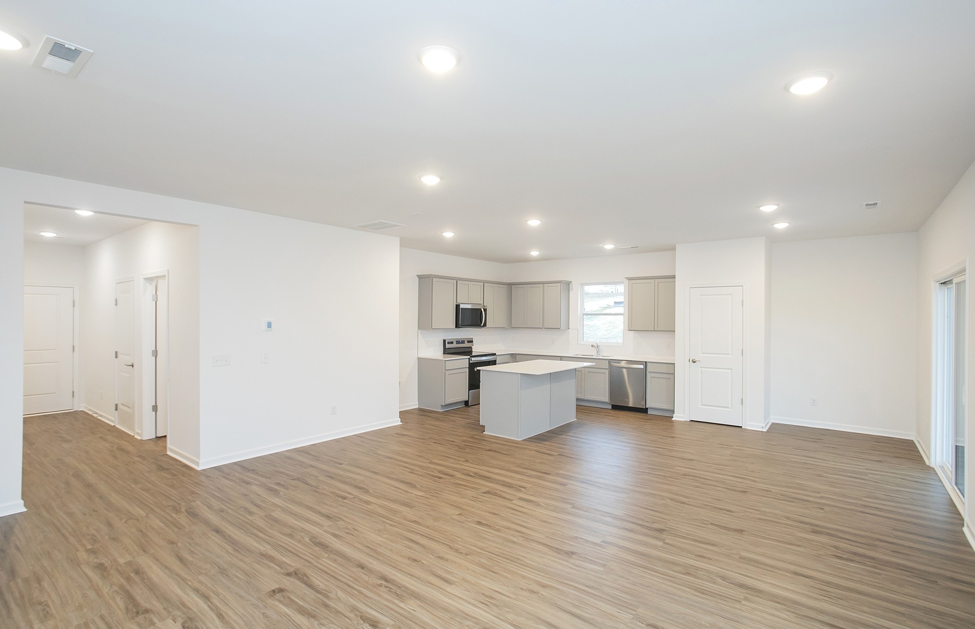 3591 Fellowship Road Columbia, TN 38401 - Photo 10 of 38 a open kitchen with white cabinets a sink dishwasher a dining table and chairs with wooden floor
