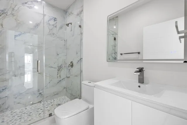 a bathroom with a sink a toilet and shower