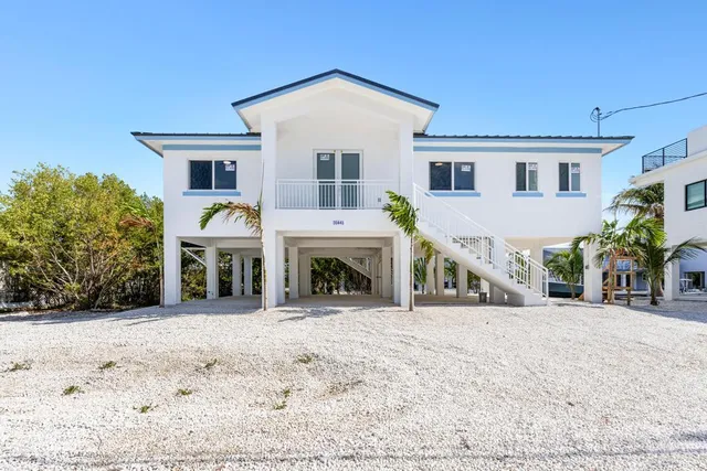 a view of a house with a yard and sitting area