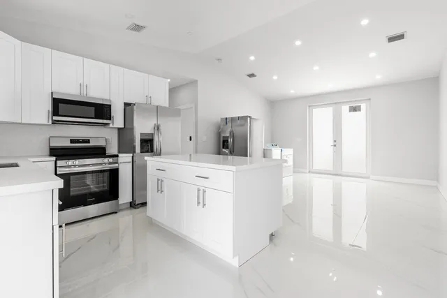 a kitchen with stainless steel appliances a refrigerator sink and microwave