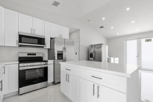 a kitchen with cabinets stainless steel appliances and counter space