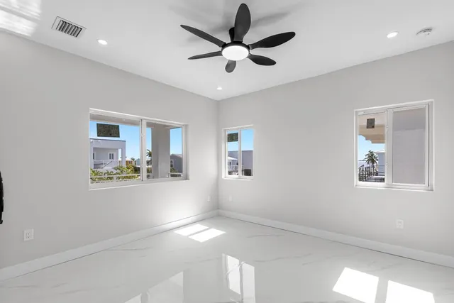a view of empty room with wooden floor and ceiling fan