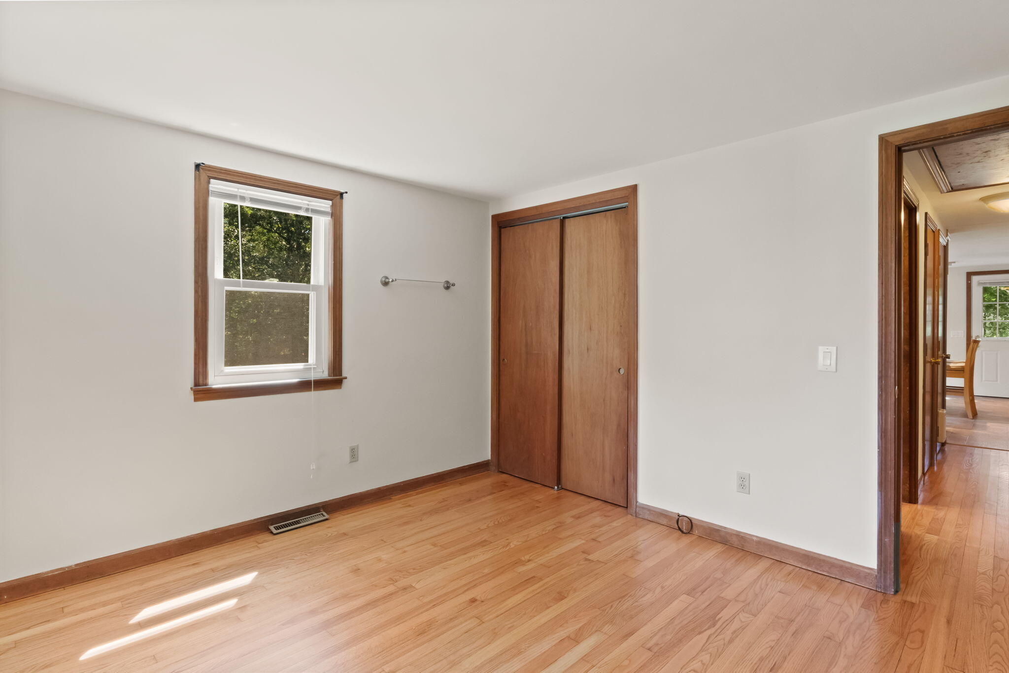 49 Russells Path Brewster, MA 02631 - Photo 21 of 37 a view of an empty room with wooden floor and a window