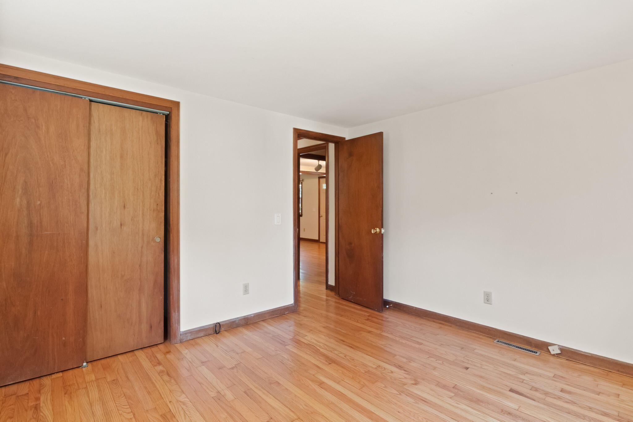 49 Russells Path Brewster, MA 02631 - Photo 22 of 37 a view of an empty room with wooden floor and a window