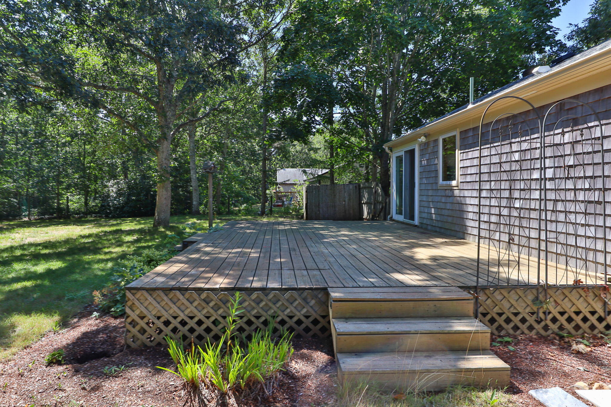 49 Russells Path Brewster, MA 02631 - Photo 33 of 37 a view of a backyard with plants and large trees