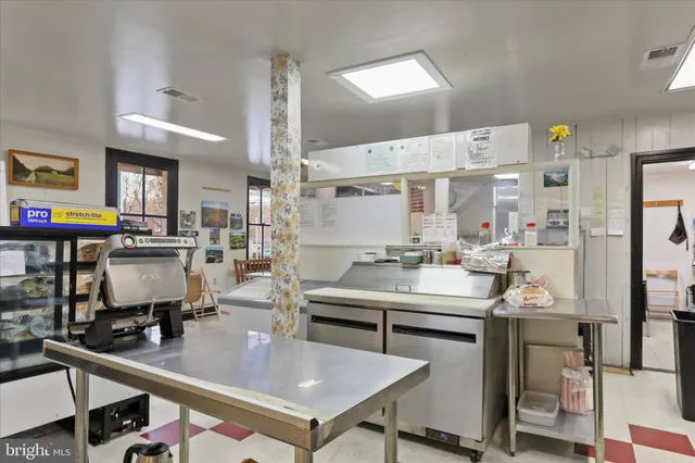 a kitchen with stainless steel appliances kitchen island granite countertop a lot of counter space and cabinets