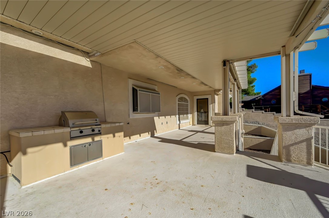 640 North Racetrack Road Henderson, NV 89015 - Photo 58 of 65 An inviting covered patio offers a dedicated outdoor kitchen with a built-in grill.