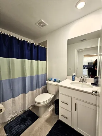 a bathroom with a sink a toilet a mirror and vanity