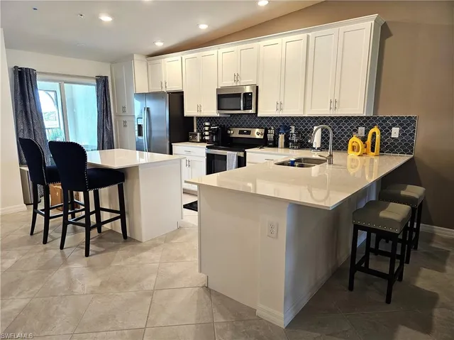 a kitchen with a sink white cabinets and appliances