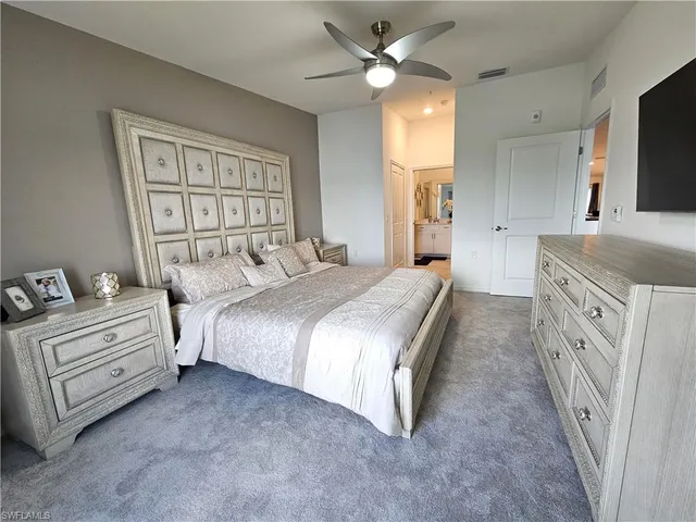 a spacious bedroom with a large bed and a chandelier