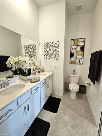 a spacious bathroom with a double vanity sink and a toilet