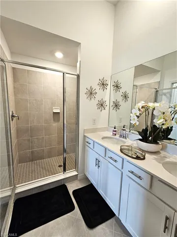 a spacious bathroom with a granite countertop sink a toilet a mirror and shower