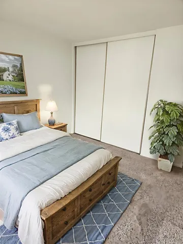 a bedroom with a bed and painting on the wall