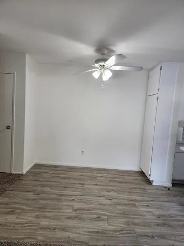 a view of an empty room with wooden floor