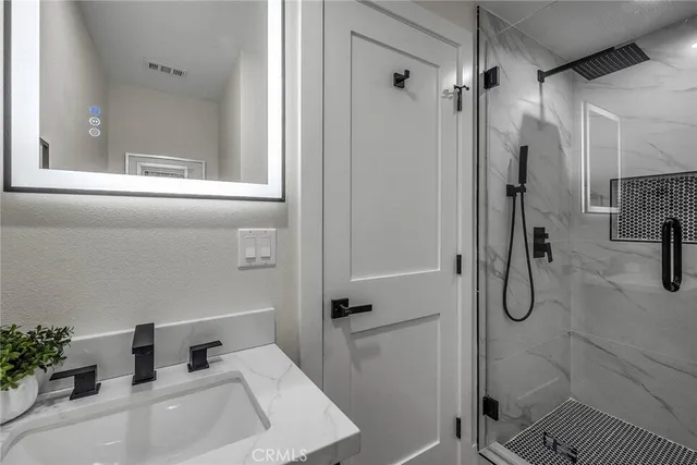 a bathroom with a tub shower vanity and a sink
