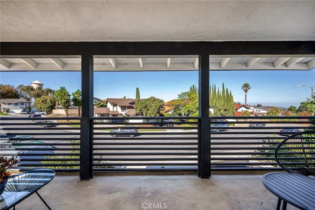 a view of a balcony with chairs and a potted plant