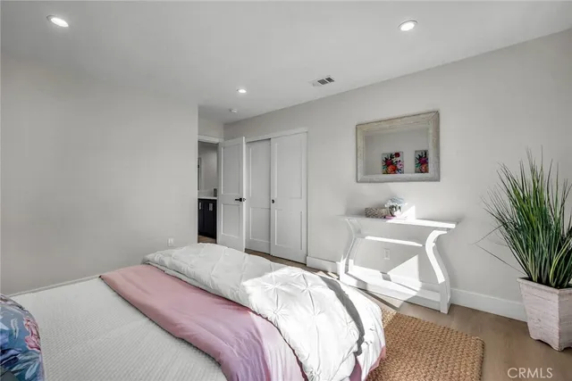 a bedroom with a bed and a potted plant