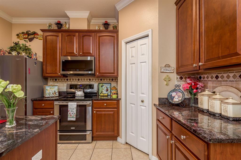 19216 Inlet Cove Court Lutz, FL 33558 - Photo 15 of 41 a kitchen with granite countertop a sink stove and cabinets
