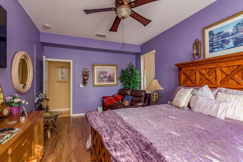 19216 Inlet Cove Court Lutz, FL 33558 - Photo 25 of 41 a bedroom with a bed a dresser and potted plants