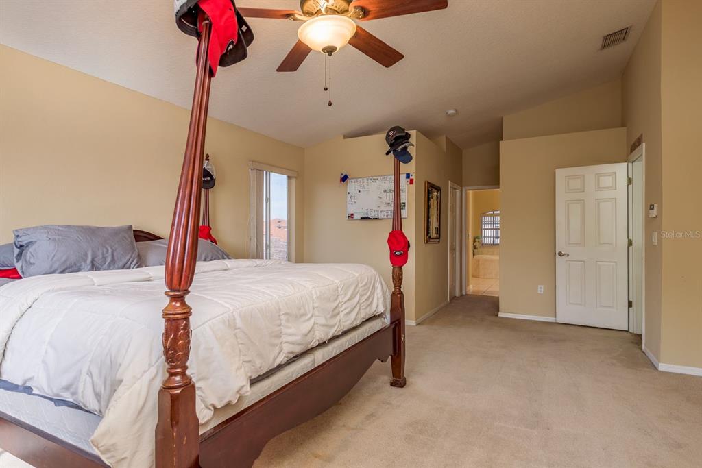 19216 Inlet Cove Court Lutz, FL 33558 - Photo 32 of 41 a bed room with a bed and a ceiling fan