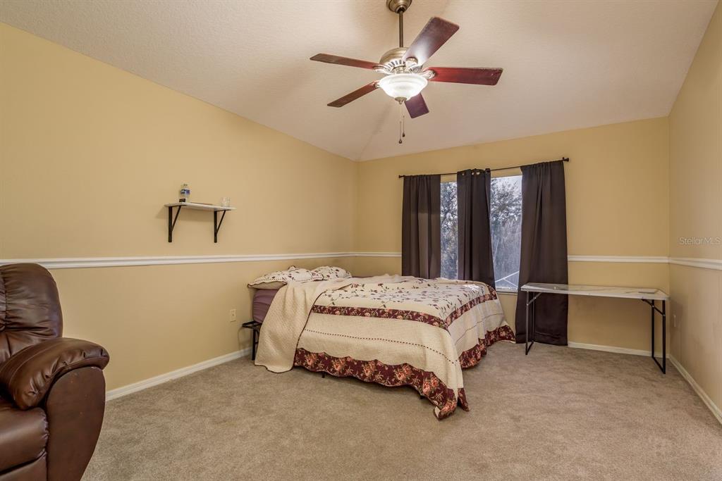 19216 Inlet Cove Court Lutz, FL 33558 - Photo 34 of 41 a bedroom with a bed dresser and a window