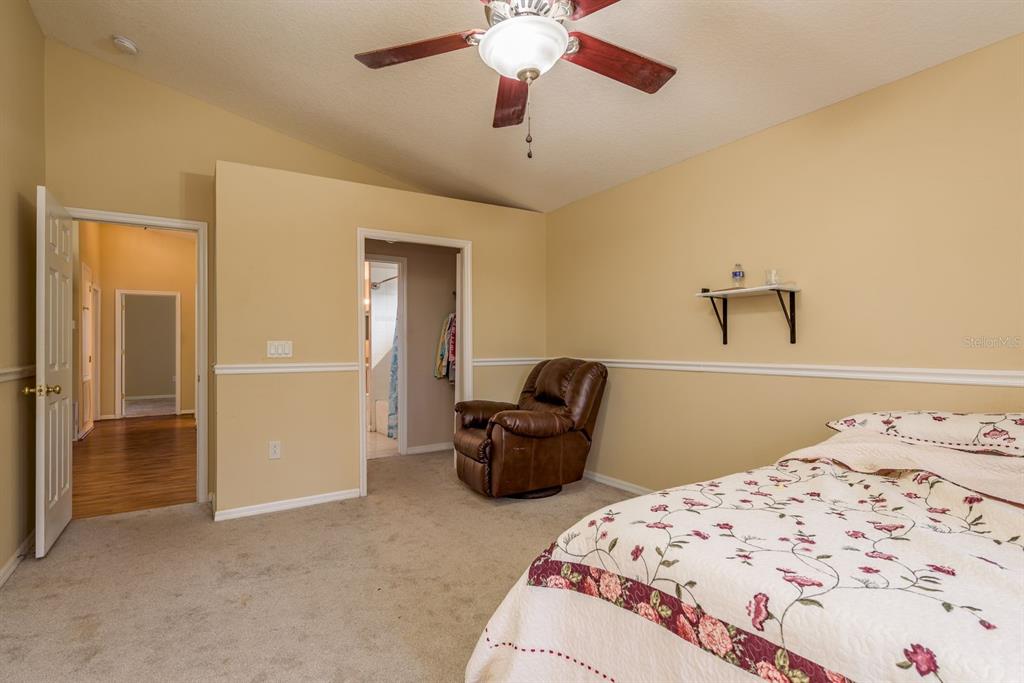 19216 Inlet Cove Court Lutz, FL 33558 - Photo 36 of 41 a bedroom with a bed and ceiling fan