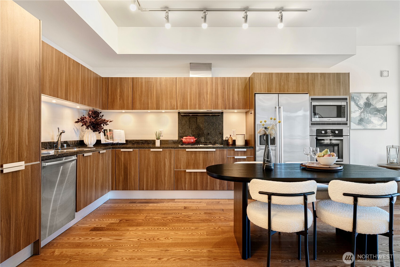 1920 4th Avenue, Unit 1809 Seattle, WA 98101 - Photo 9 of 30 a kitchen with stainless steel appliances a dining table chairs and a refrigerator