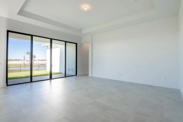 a view of an empty room with wooden floor and a sliding door