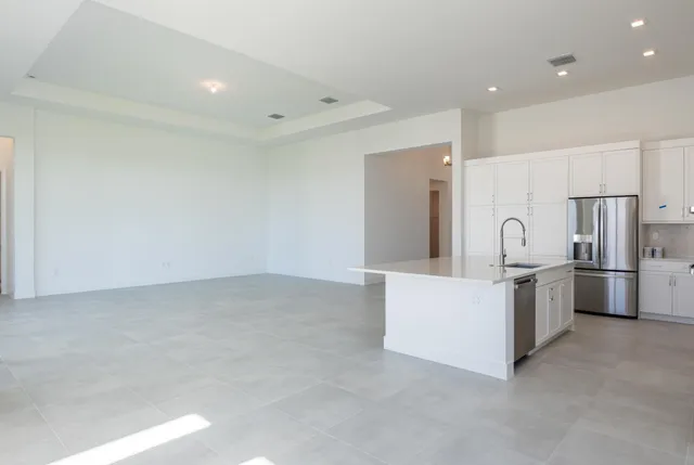 a view of kitchen with stainless steel appliances refrigerator sink and cabinets