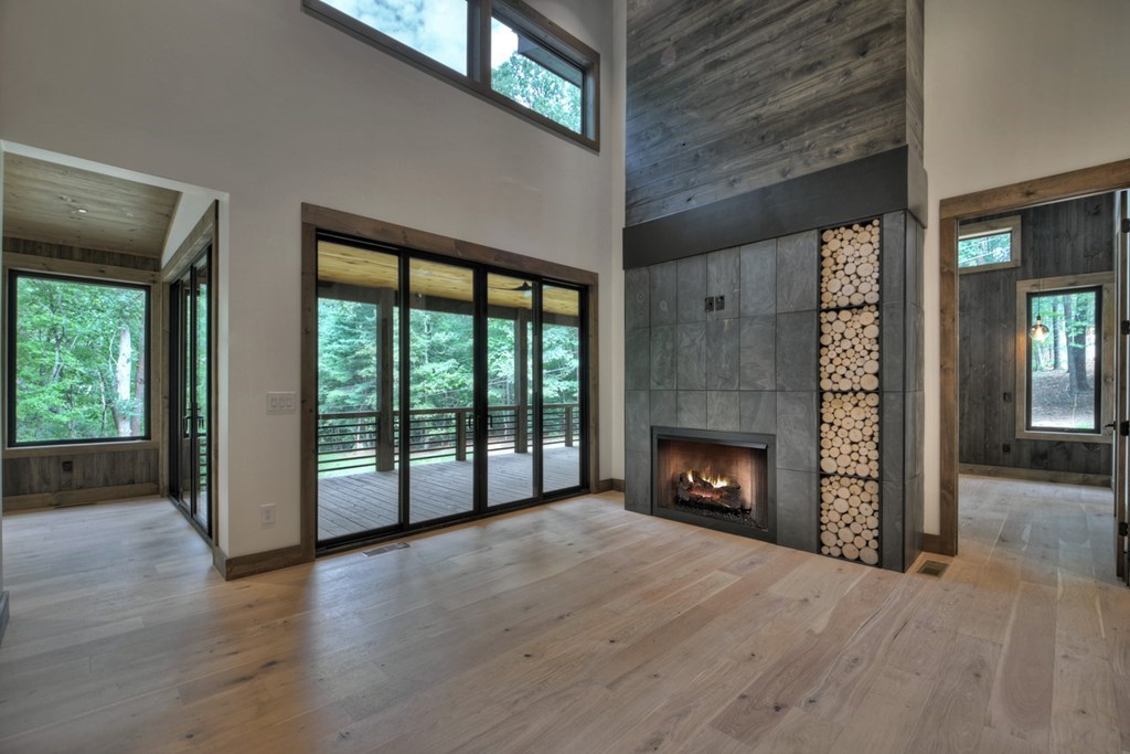 2596 Hwy 2 Blue Ridge Blue Ridge, GA 30513 - Photo 5 of 56 an empty room with wooden floor fireplace and windows
